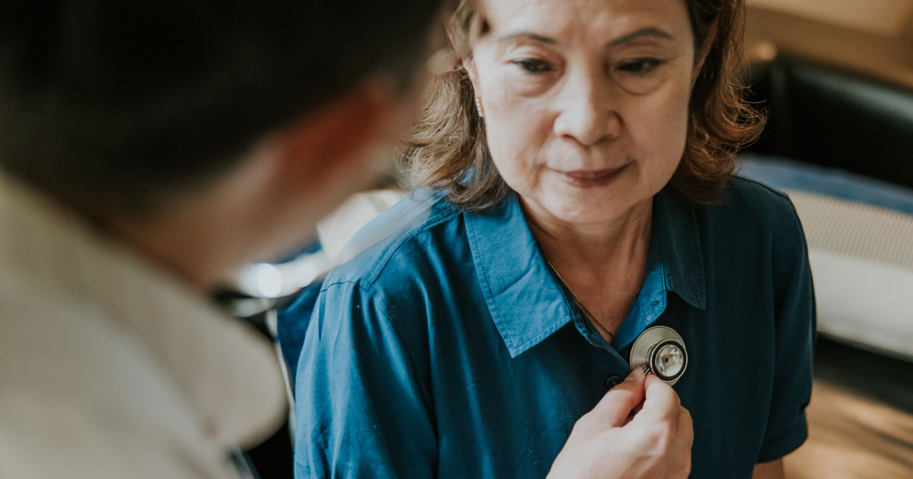 A photo of a healthcare provider listening to a person's lungs. A provider will perform imaging tests to learn how far lung cancer has spread as part of lung cancer staging.