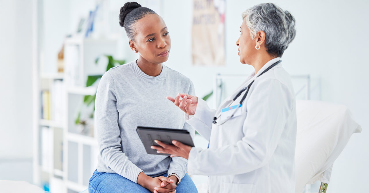 Photo of a woman and a healthcare provider discussing cervical cancer staging