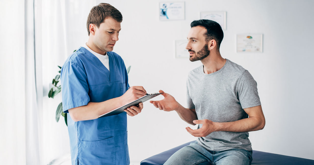 Photo of a man discussing his testicular cancer symptoms with a healthcare provider