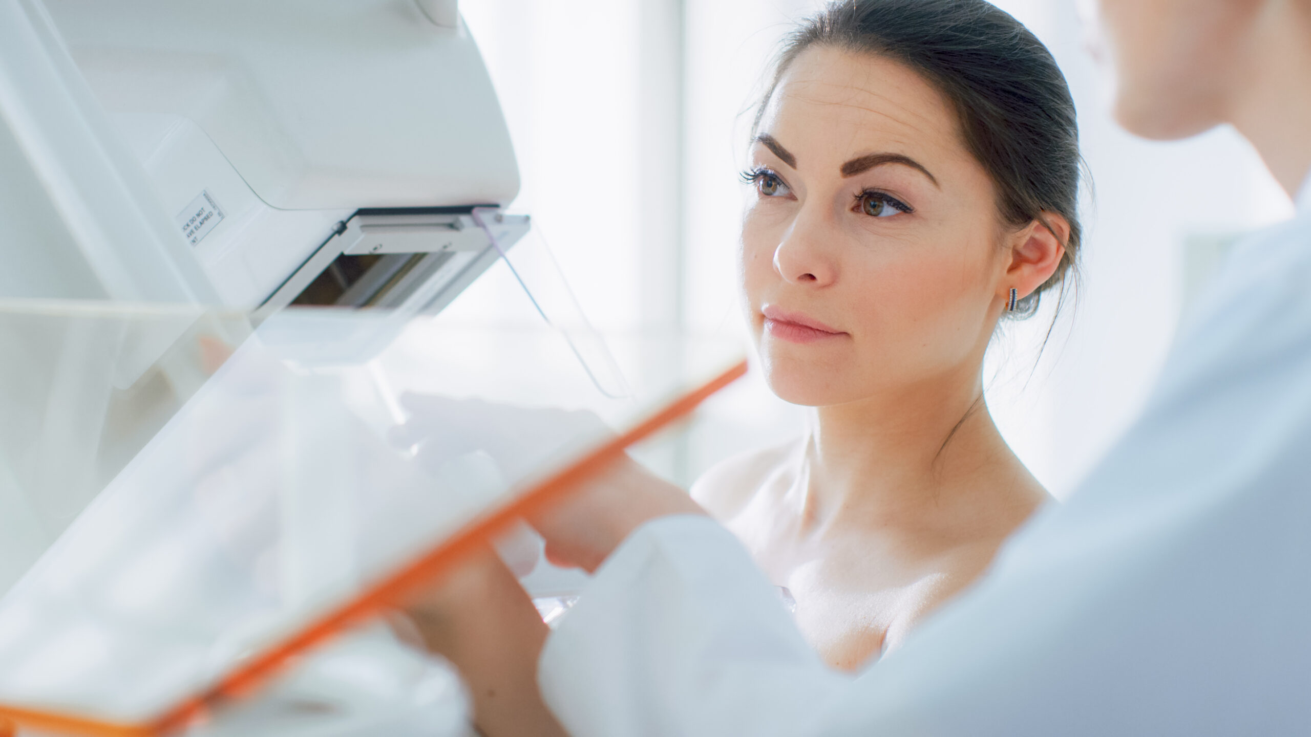 A photo of a woman ready to get a mammogram