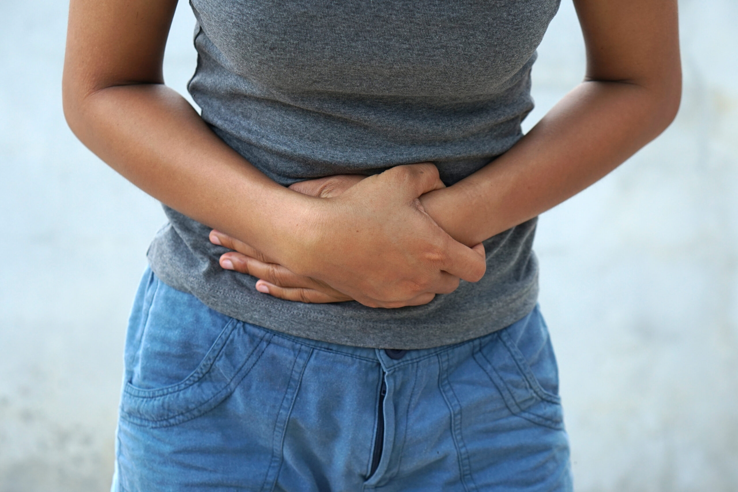 A photo of a woman holding her abdomen, possibly due to ovarian cancer
