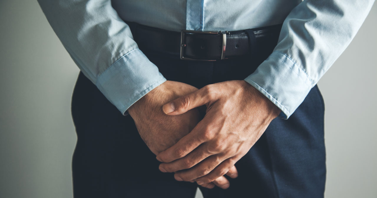 Photo of man with hands in front of crotch